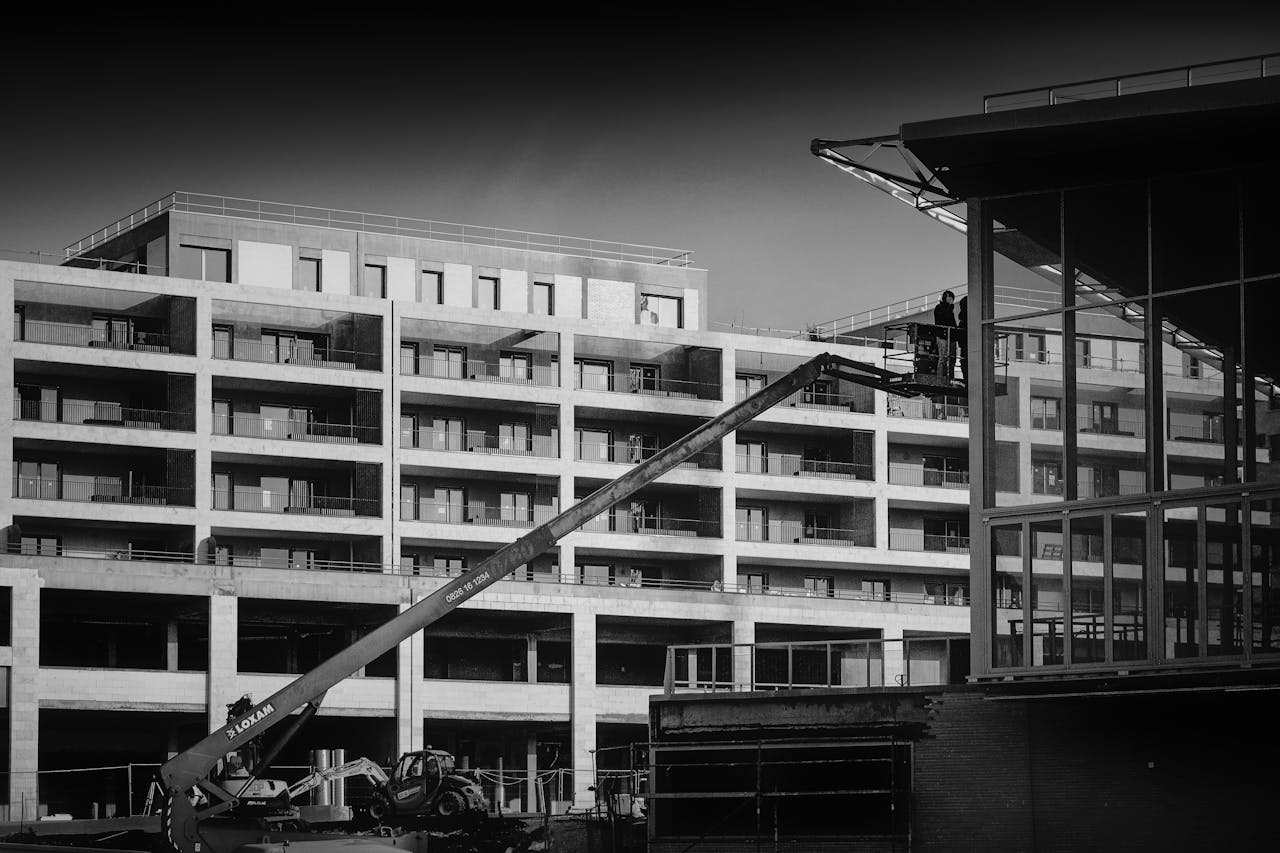 services-04 Black and white image of construction site in Bordeaux with jib crane and modern apartments.