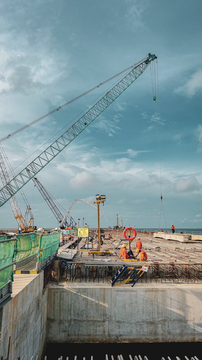 contact-img Elevated view of a construction site with cranes under a cloudy sky in West Java, Indonesia.