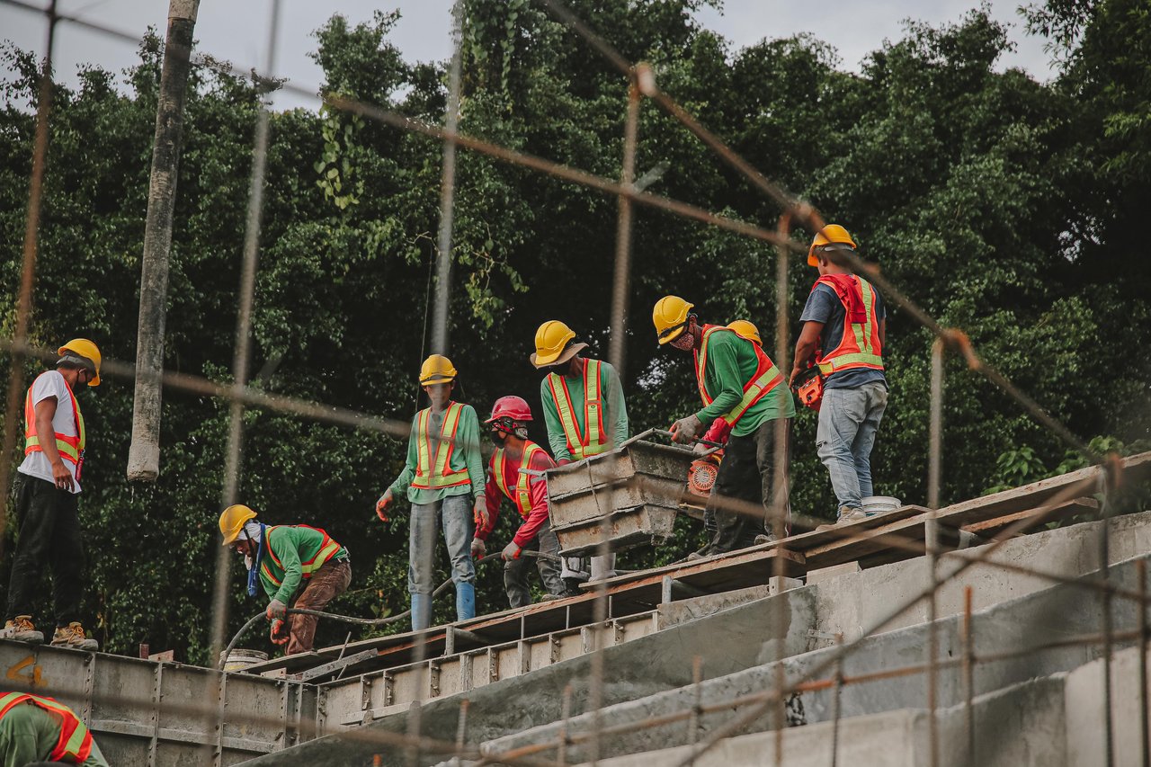 services-img Construction workers in safety gear work on a structure outdoors, emphasizing teamwork and safety.