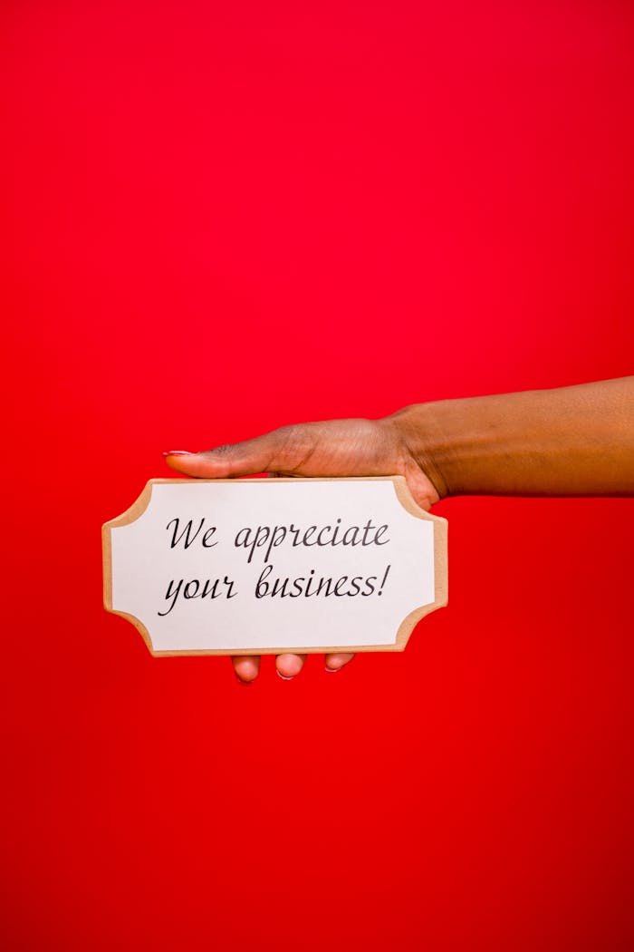 why-choose-us A hand holding an appreciation sign with the message 'We appreciate your business!' against a red backdrop.