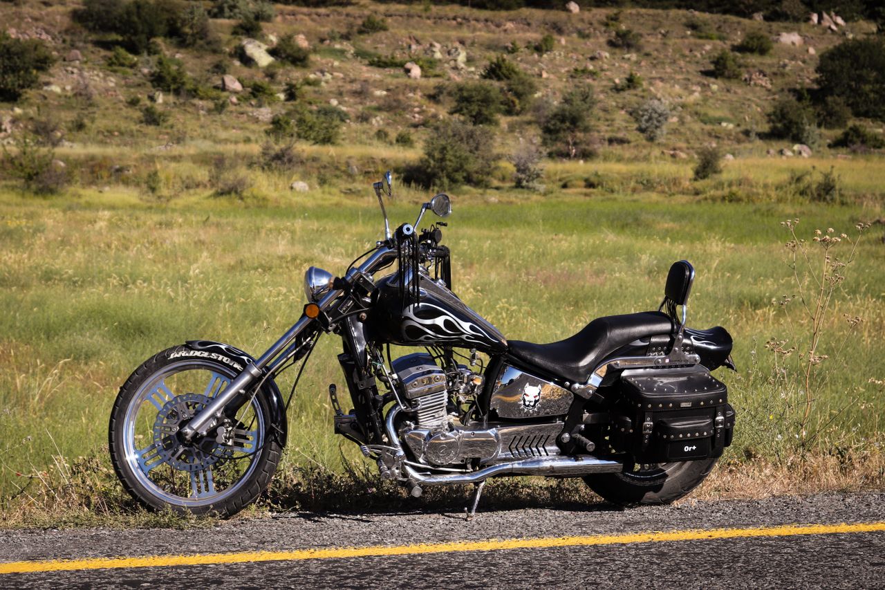Crafting Captivating Headlines: Your awesome post title goes here A vintage chopper-style motorcycle with flame design parked on a rural road.