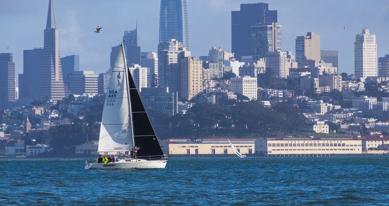 Sailboat cruising with San Francisco's iconic skyline in the background, capturing urban life and architecture.