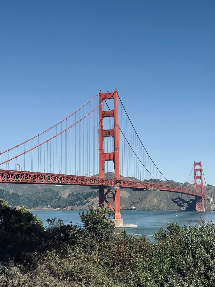 Iconic view of the Golden Gate Bridge spanning San Francisco Bay under a clear blue sky.
