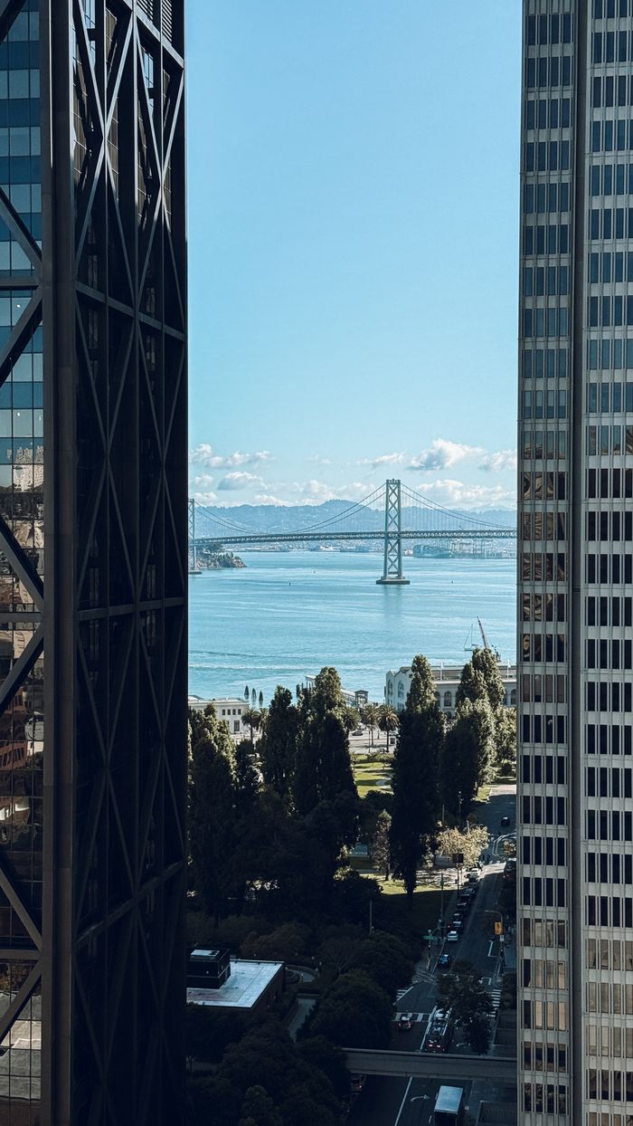 Scenic view of Bay Bridge framed by downtown skyscrapers, capturing a clear day in San Francisco.